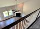 Open-concept living room boasts hardwood floors, a fan, and a fireplace, viewed from the upstairs railing at 11109 Pond Valley Ct, Charlotte, NC 28269