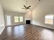 Bright living room with dark hardwood floors, fireplace, ceiling fan, and natural light at 11109 Pond Valley Ct, Charlotte, NC 28269