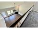 Open-concept living room boasts hardwood floors, a fan, and a fireplace, viewed from the upstairs railing at 11109 Pond Valley Ct, Charlotte, NC 28269