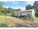 Back exterior with a grill and overgrown landscaping at 112 Harmony Trl, Gastonia, NC 28056