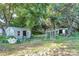 Large backyard featuring two small metal buildings with windows and a chain link enclosure at 112 Harmony Trl, Gastonia, NC 28056