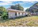 Exterior view of a one-story home with gray siding and overgrown vegetation at 112 Harmony Trl, Gastonia, NC 28056