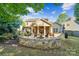 Landscaped backyard featuring a stone fire pit with seating, patio, and lush greenery at 1237 Saint Johns Ave, Matthews, NC 28104
