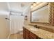 Well-lit bathroom with a granite countertop vanity, decorative mirror, and shower-tub combination at 1237 Saint Johns Ave, Matthews, NC 28104