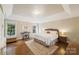Spacious bedroom featuring hardwood floors, tray ceiling, windows, and a neutral color palette at 1237 Saint Johns Ave, Matthews, NC 28104