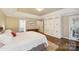 Bright bedroom with hardwood flooring, a large bed, custom built-ins and access to outdoor patio at 1237 Saint Johns Ave, Matthews, NC 28104