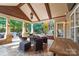 Covered patio with stone flooring, outdoor lighting, ceiling fan, and outdoor dining area at 1237 Saint Johns Ave, Matthews, NC 28104