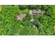 Aerial view of a home surrounded by lush trees with storage areas and a long gravel drive at 1556 Stanley Lucia Rd, Mount Holly, NC 28120