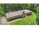 Charming single-story home with a manicured lawn and surrounded by mature trees and lush greenery at 1556 Stanley Lucia Rd, Mount Holly, NC 28120