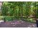 Back deck made of wood features a black metal railing and stairs overlooking the private green space at 1556 Stanley Lucia Rd, Mount Holly, NC 28120
