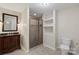 Bathroom boasts shower, toilet, and vanity with sink, a tiled shower with glass door and open shelves at 1556 Stanley Lucia Rd, Mount Holly, NC 28120