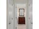 An elegant bathroom vanity is showcased through an open doorway, complete with a dark wood cabinet and a framed mirror at 1556 Stanley Lucia Rd, Mount Holly, NC 28120