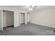 Carpeted bedroom showing a ceiling fan, 2 closets, neutral walls, with doorway views to hall at 1556 Stanley Lucia Rd, Mount Holly, NC 28120