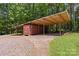 View of open sided structure with containers used for storage on a lot with mature trees at 1556 Stanley Lucia Rd, Mount Holly, NC 28120