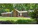 Charming home featuring a brick chimney and a well-maintained lawn with mature trees providing shade in a peaceful setting at 1556 Stanley Lucia Rd, Mount Holly, NC 28120