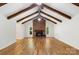 Expansive living room showcasing a brick fireplace, exposed beams, and hardwood floors, offering rustic charm and modern appeal at 1556 Stanley Lucia Rd, Mount Holly, NC 28120