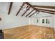 Spacious living room featuring exposed beams and beautiful hardwood flooring creating a cozy and inviting atmosphere at 1556 Stanley Lucia Rd, Mount Holly, NC 28120