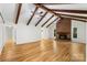 Living room with exposed beams, fireplace, hardwood flooring creating a warm, inviting atmosphere for gathering and relaxation at 1556 Stanley Lucia Rd, Mount Holly, NC 28120