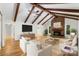 Living room featuring exposed beams, a brick fireplace, hardwood flooring, and modern furniture offering a cozy place to relax at 1556 Stanley Lucia Rd, Mount Holly, NC 28120