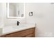 Sleek bathroom featuring a modern vanity with a quartz countertop and a backlit mirror at 177 Georgia Sw St, Concord, NC 28025