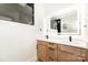 Modern bathroom featuring a double sink vanity, neutral walls, wood cabinets and a lighted mirror at 177 Georgia Sw St, Concord, NC 28025