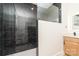 Modern bathroom featuring a dark tiled shower, neutral walls, and a wooden vanity at 177 Georgia Sw St, Concord, NC 28025