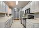 Well-lit kitchen with white cabinets, tile countertops, stainless steel appliances, and tile flooring at 2289 Veery Ln, Rock Hill, SC 29732