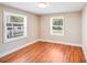 Bright bedroom with two windows, hardwood flooring, and neutral paint at 2405 Greenland Ave, Charlotte, NC 28208
