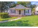 Beautiful one-story home with front porch, well maintained yard, and mature trees at 2405 Greenland Ave, Charlotte, NC 28208