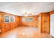 Cozy room with wood paneling, two large windows, and fan at 2405 Greenland Ave, Charlotte, NC 28208