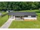 Ranch home with black roof, white painted brick, and ample yard at 2610 Fairgreen Dr, Gastonia, NC 28056
