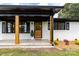 Charming home featuring a front porch with a wooden door, black shutters, and painted brick at 2610 Fairgreen Dr, Gastonia, NC 28056