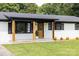 A front view of a charming white brick home with black trim and a well-manicured lawn at 2610 Fairgreen Dr, Gastonia, NC 28056