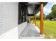 Inviting porch with white brick, wooden supports, and a long view of a green lawn at 2610 Fairgreen Dr, Gastonia, NC 28056