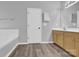 Bathroom features a built-in tub, wooden vanity, neutral paint, and modern fixtures at 280 Glenn Allen Rd, Mooresville, NC 28115