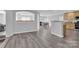 Open concept living area with wood-look floors, kitchen and fireplace with a view into the living and dining areas at 280 Glenn Allen Rd, Mooresville, NC 28115