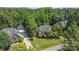 Brick home with a manicured lawn, long driveway, and separate garage sits amongst lush green trees at 2909 Arbor Knl, Concord, NC 28025