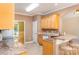 Sunlit kitchen features wood cabinetry, granite counters, and cozy breakfast bar with beige stools at 2909 Arbor Knl, Concord, NC 28025