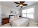 Cozy bedroom with a queen-sized bed, ceiling fan, and large window for ample natural light at 298 Bridges Farm Rd, Mooresville, NC 28115