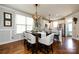 A dining room and kitchen combo features hardwood floors and a breakfast bar with stools for extra seating at 298 Bridges Farm Rd, Mooresville, NC 28115