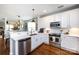 Bright kitchen with white cabinets, stainless steel appliances and hardwood floors and an open view to dining room at 298 Bridges Farm Rd, Mooresville, NC 28115