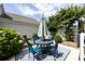A shaded patio with a round table, chairs, and a vibrant blue area rug at 298 Bridges Farm Rd, Mooresville, NC 28115