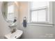 Charming powder room featuring a stylish vessel sink and a bright window for natural light at 298 Bridges Farm Rd, Mooresville, NC 28115