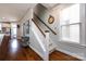 Elegant staircase with wooden handrail and white banister, complemented by hardwood floors at 298 Bridges Farm Rd, Mooresville, NC 28115