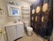 A cozy bathroom featuring a vanity, toilet, a framed mirror, and a decorative shower curtain at 315 Second St, Stanley, NC 28164
