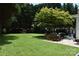 Spacious backyard featuring a lush lawn, mature trees, and an inviting patio seating area, perfect for outdoor entertaining at 318 N Laurel N St, Lincolnton, NC 28092