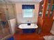 Bright bathroom featuring a glass shower, a standalone tub, and elegant fixtures, alongside a wooden cabinet at 318 N Laurel N St, Lincolnton, NC 28092