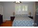 Comfortable bedroom featuring a bed with patterned bedding, two side tables and natural light at 318 N Laurel N St, Lincolnton, NC 28092
