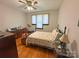 Bedroom with wooden floors, a ceiling fan, neutral walls, and a traditional-style bed with floral bedding at 318 N Laurel N St, Lincolnton, NC 28092