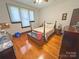 Bedroom with wooden floors, a ceiling fan, neutral walls, and a traditional-style bed with floral bedding at 318 N Laurel N St, Lincolnton, NC 28092